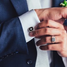 elegant young fashion man fixing cufflinks